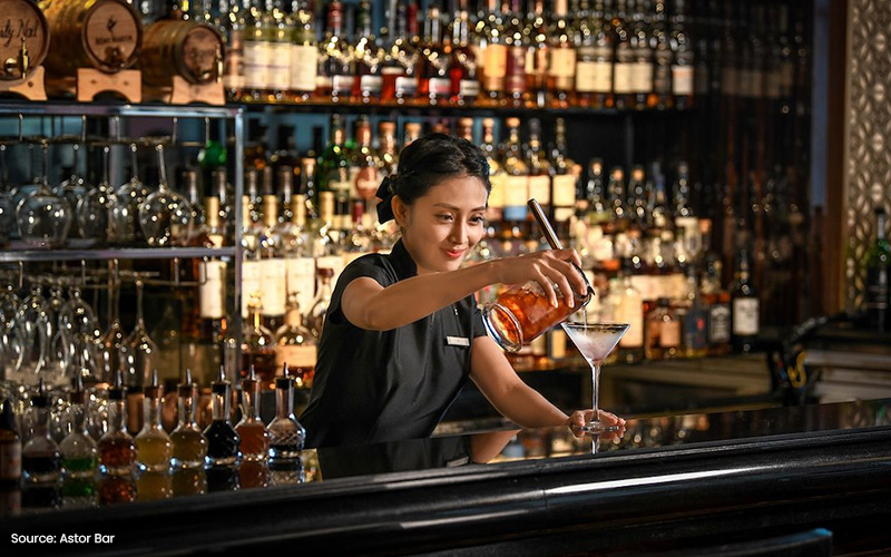 Astor Bar bartender mixing a cocktail at a live music bar.