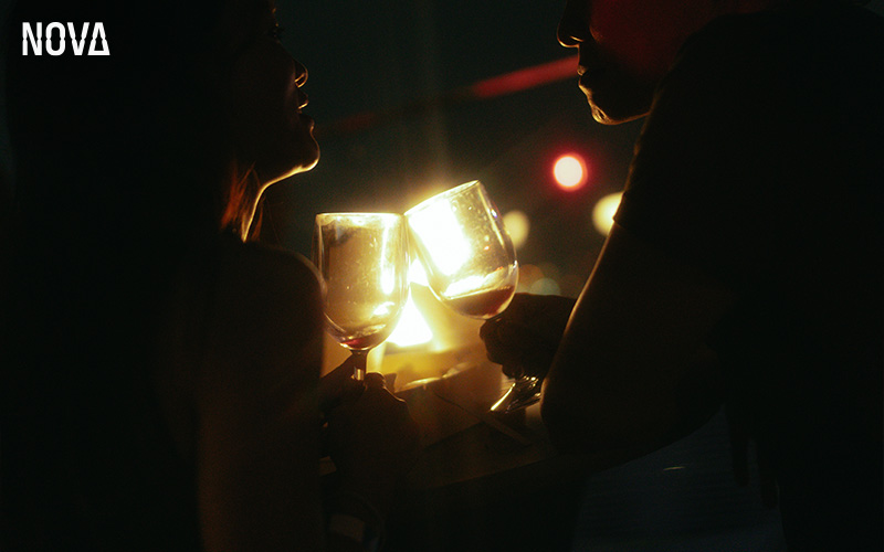 Two people toasting with wine at Nova Bar.